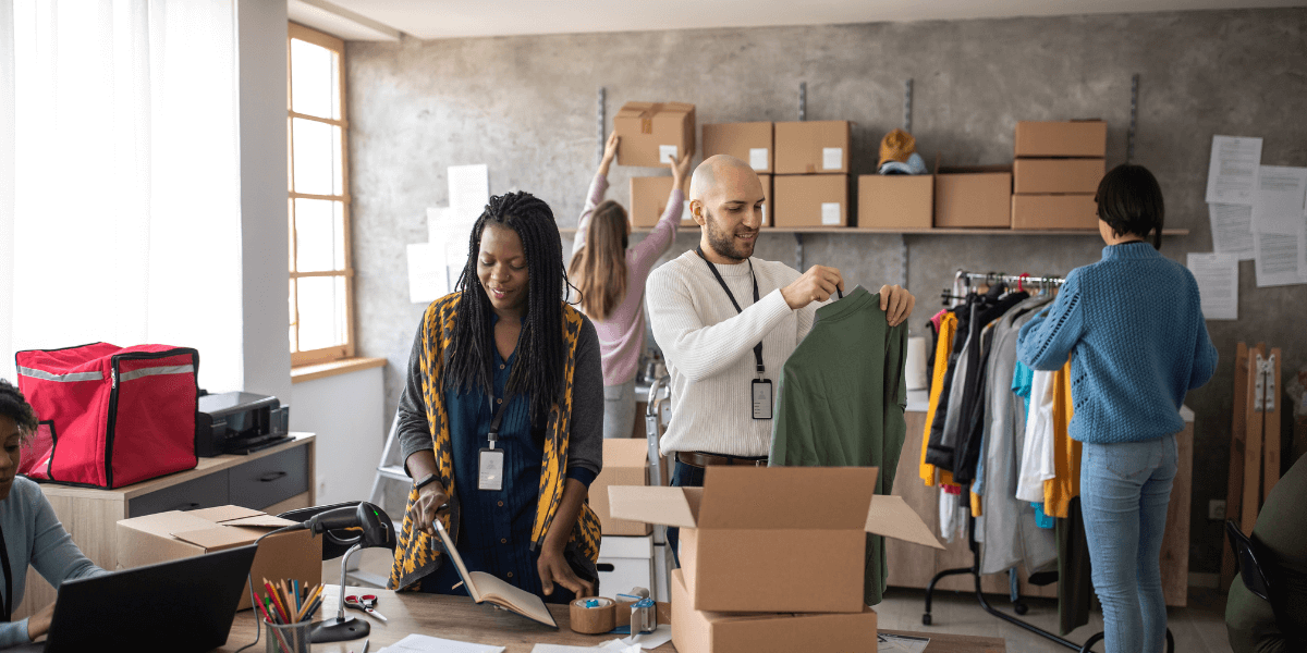 A team of 4 merch managers boxing and sorting merchandise for their ecommerce orders.