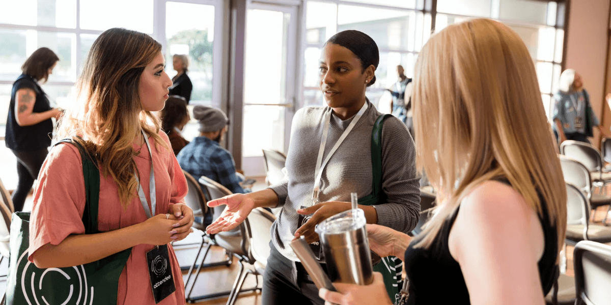 Attendees with lanyards talk during a networking break at HubSpot UNBOUND 2026 in Boston
