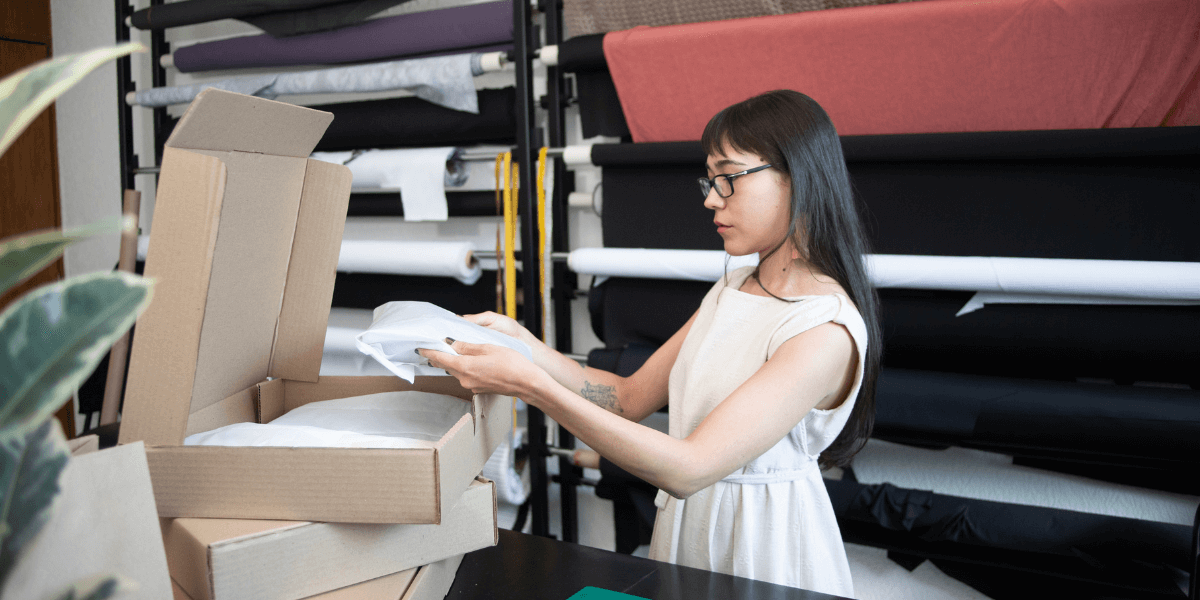 A young woman packaging items being bought online to be shipped to the customer.