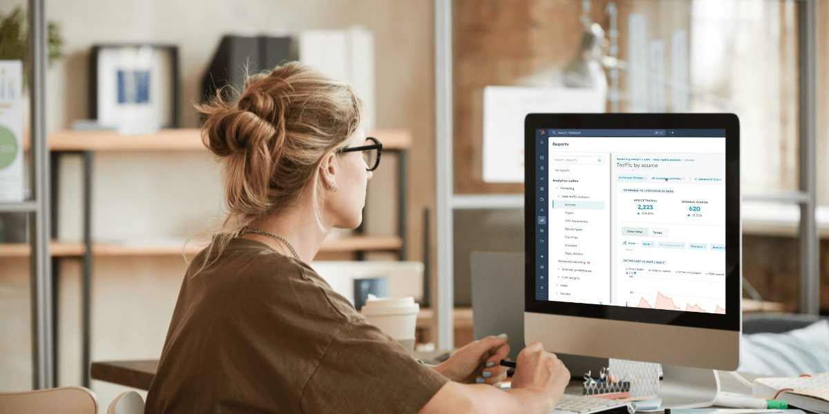 Young professional woman wearing glasses while looking at reports on her monitor. 
