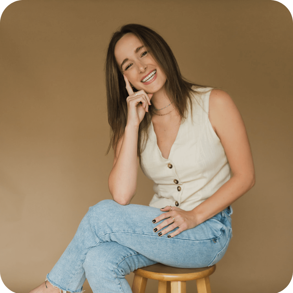 Carly's headshot on a light brown background.