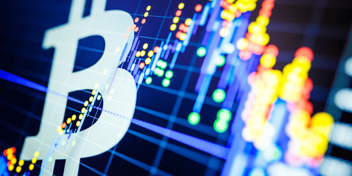 Large Bitcoin symbol overlaid with colorful candlestick and line charts representing cryptocurrency trading and market analysis.