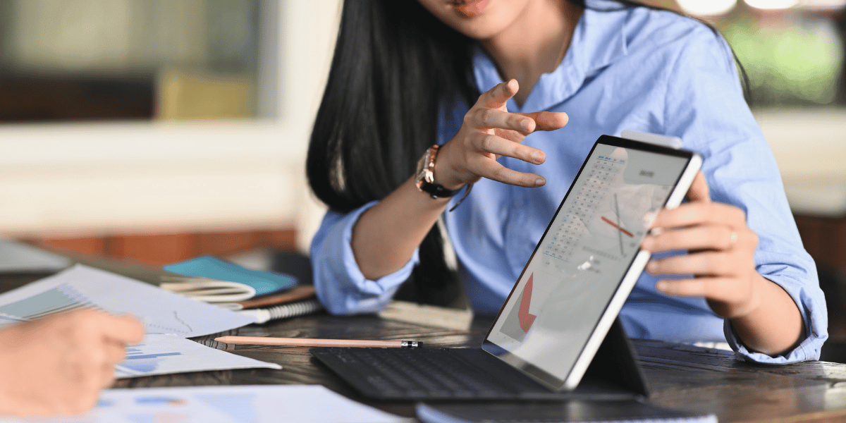 Woman review website traffic metrics on laptop with customer