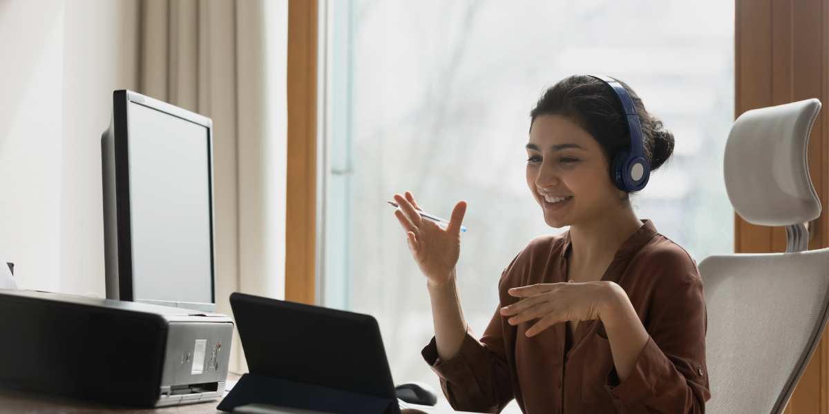 Woman wearing headphones engaging in a video call, representing customer service training and performance metrics.